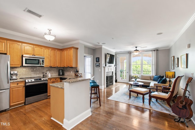 340 Allister Dr Unit 201, Raleigh, NC 27609 - kitchen with a kitchen breakfast bar, stainless steel appliances, open floor plan, a peninsula, and visible vents