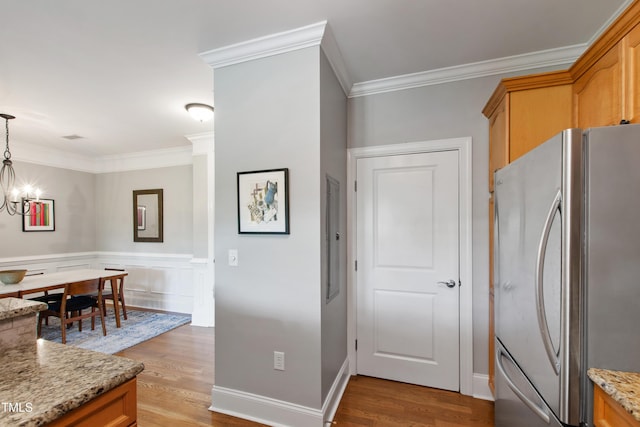 340 Allister Dr Unit 201, Raleigh, NC 27609 - kitchen with crown molding, freestanding refrigerator, light stone counters, light wood finished floors, and a notable chandelier