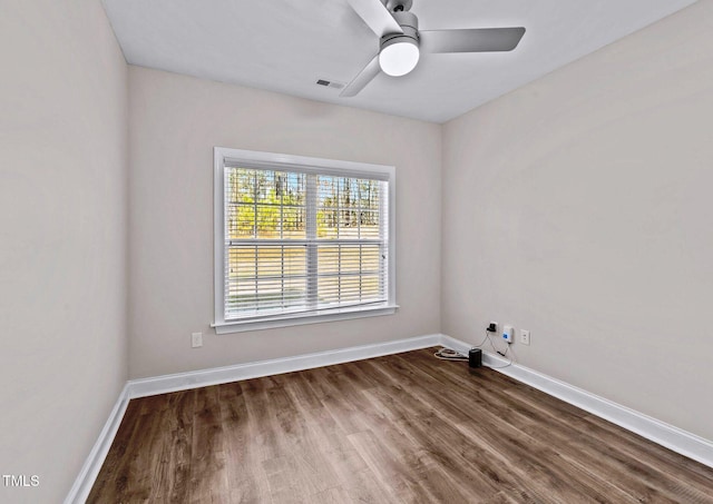 unfurnished room featuring baseboards, wood finished floors, visible vents, and ceiling fan
