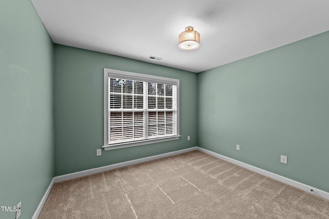 carpeted empty room with visible vents and baseboards