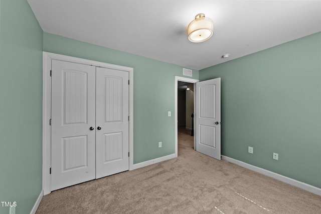 unfurnished bedroom featuring baseboards, a closet, visible vents, and carpet