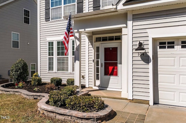property entrance featuring central air condition unit and an attached garage