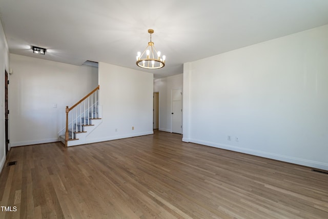 118 Riverwood Dr, Fuquay Varina, NC 27526 - unfurnished room featuring visible vents, baseboards, stairs, wood finished floors, and a notable chandelier