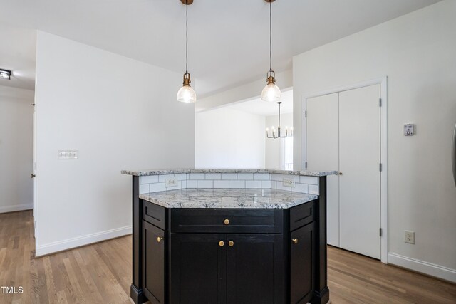 118 Riverwood Dr, Fuquay Varina, NC 27526 - kitchen featuring baseboards, a kitchen island, light wood-style floors, and dark cabinetry