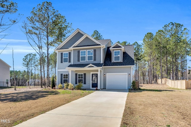 view of front of property featuring a garage, driveway, a front yard, and fence