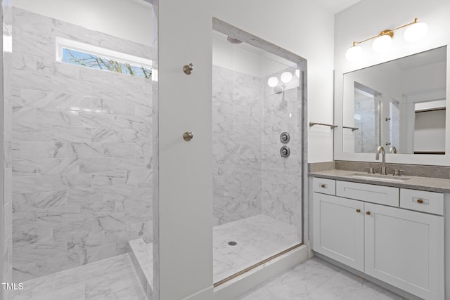 full bath with vanity, marble finish floor, and a tile shower
