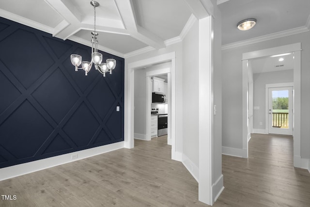 unfurnished dining area with coffered ceiling, ornamental molding, a chandelier, and wood finished floors
