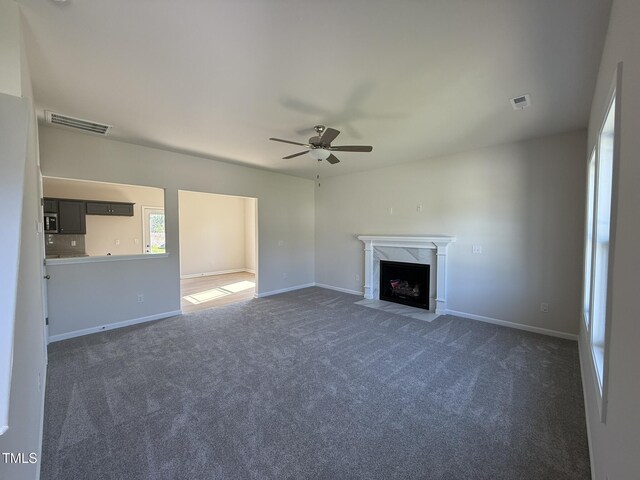 87 Heatherglenn Cir, Princeton, NC 27569 - unfurnished living room with dark colored carpet, baseboards, a fireplace, visible vents, and ceiling fan