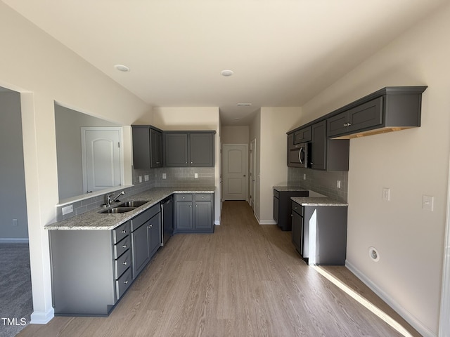 87 Heatherglenn Cir, Princeton, NC 27569 - kitchen featuring baseboards, dishwasher, a sink, stainless steel microwave, and light wood-style flooring