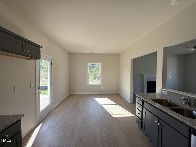 87 Heatherglenn Cir, Princeton, NC 27569 - kitchen with baseboards, light wood-type flooring, a sink, and light stone counters