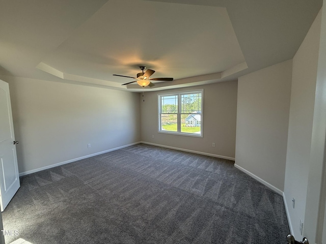 87 Heatherglenn Cir, Princeton, NC 27569 - spare room with dark carpet, baseboards, a raised ceiling, and a ceiling fan