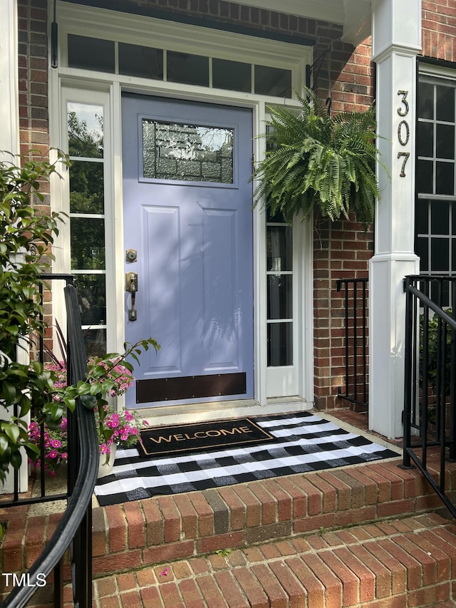 property entrance with brick siding and a porch
