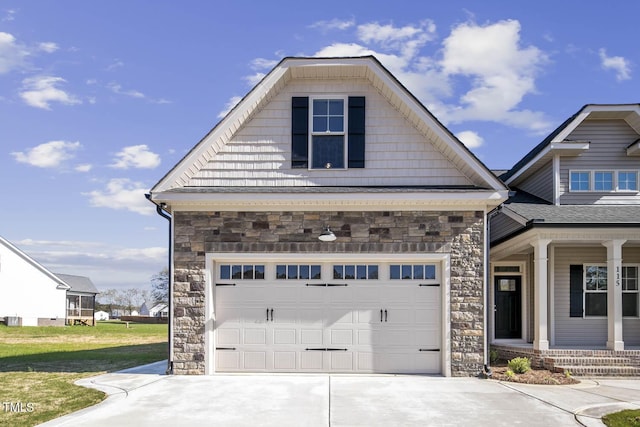 view of front of house featuring driveway, a porch, stone siding, and a garage