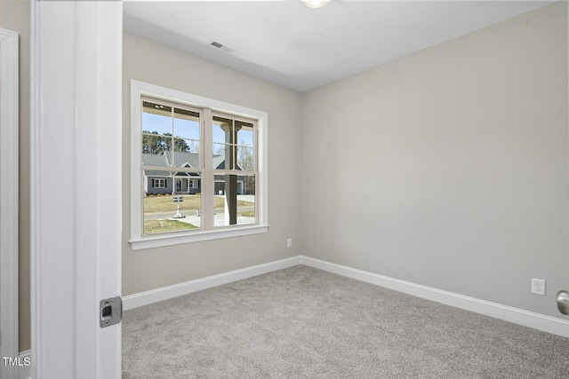 spare room with baseboards, visible vents, and carpet