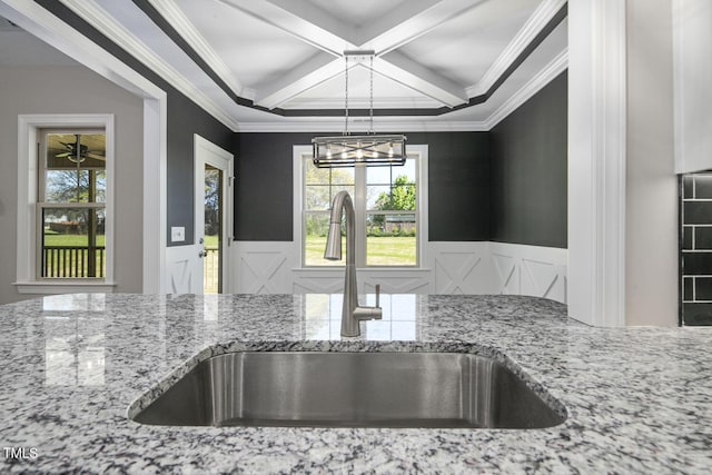 room details with a sink, wainscoting, and light stone counters