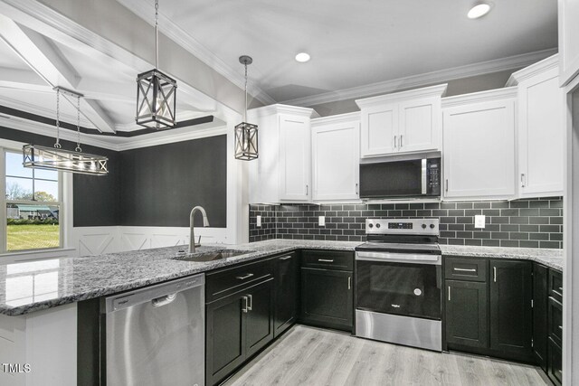 kitchen featuring white cabinetry, a sink, stainless steel appliances, and dark cabinetry