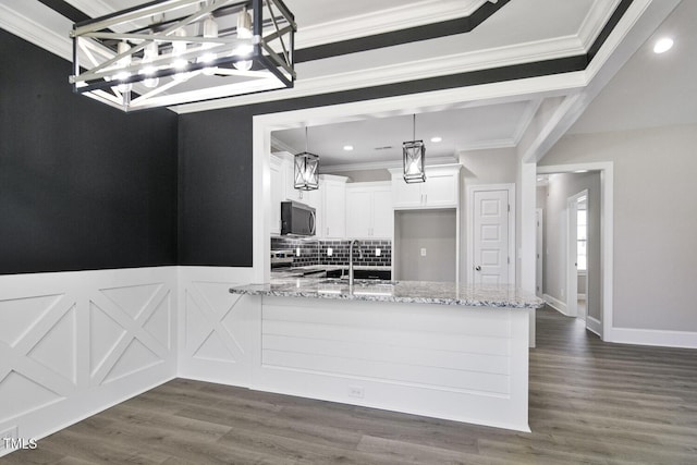 kitchen featuring white cabinetry, stainless steel electric range, light stone countertops, a sink, and a peninsula