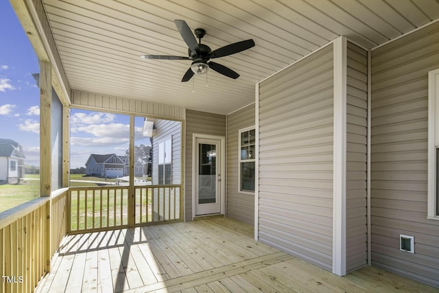 unfurnished sunroom featuring a ceiling fan