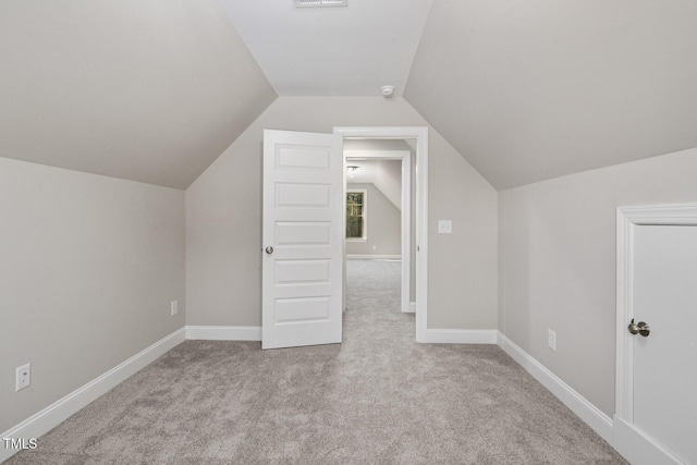 additional living space featuring baseboards, vaulted ceiling, and carpet