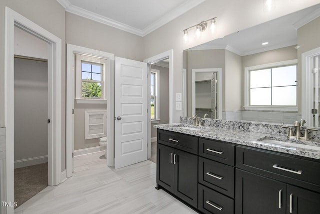 full bath with toilet, a sink, crown molding, and a healthy amount of sunlight