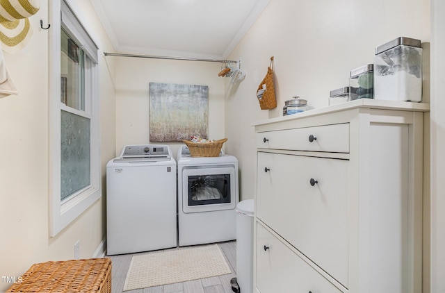 washroom featuring crown molding, washing machine and dryer, and light wood-type flooring