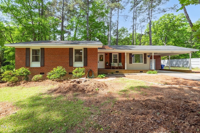 view of front of home featuring brick siding, fence, a carport, crawl space, and concrete driveway