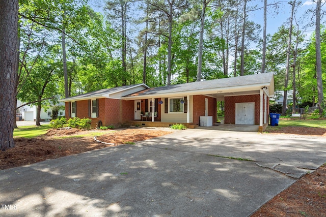 ranch-style home with concrete driveway, a carport, covered porch, and brick siding