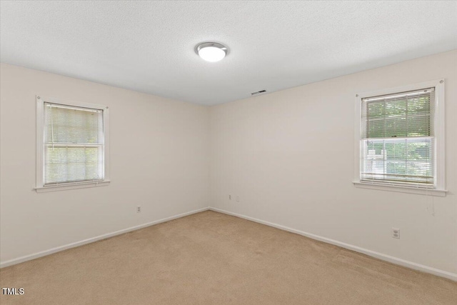 901 Emory Ln, Raleigh, NC 27609 - empty room featuring light carpet, baseboards, and a textured ceiling