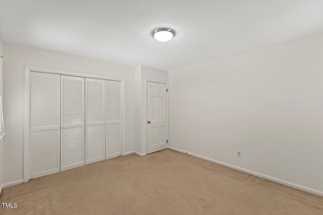 901 Emory Ln, Raleigh, NC 27609 - unfurnished bedroom featuring light colored carpet, baseboards, and a closet