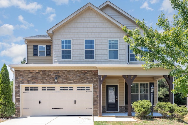 craftsman house featuring a porch, an attached garage, driveway, and stone siding