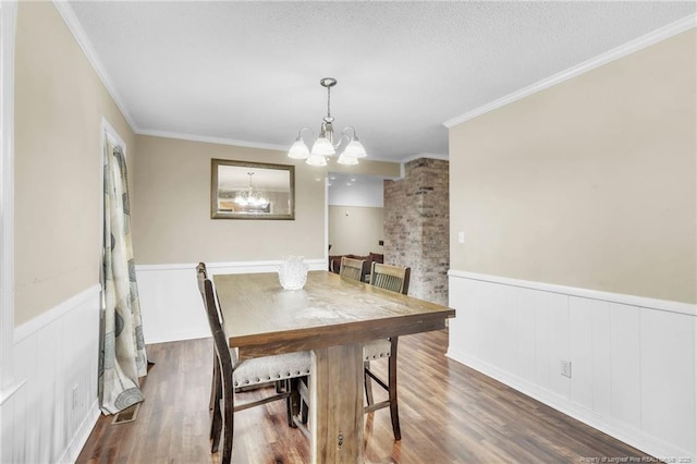 12621 Coble Dr, Laurinburg, NC 28352 - dining area with ornamental molding, wainscoting, wood finished floors, a notable chandelier, and a textured ceiling