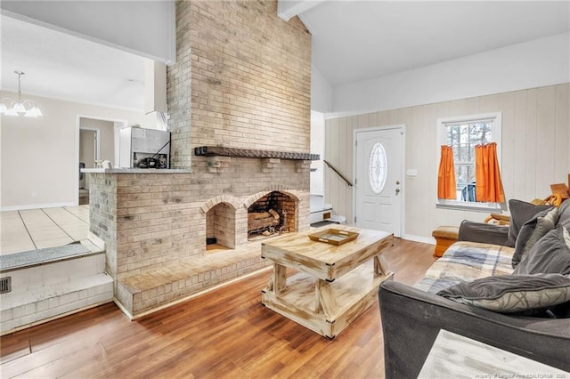 12621 Coble Dr, Laurinburg, NC 28352 - living area featuring beam ceiling, high vaulted ceiling, wood finished floors, an inviting chandelier, and a fireplace