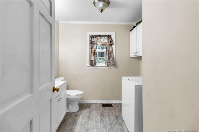 12621 Coble Dr, Laurinburg, NC 28352 - bathroom featuring visible vents, baseboards, toilet, ornamental molding, and wood finished floors
