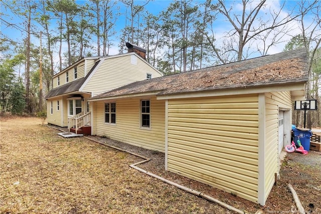 12621 Coble Dr, Laurinburg, NC 28352 - view of home's exterior featuring a shingled roof, a gambrel roof, and a chimney