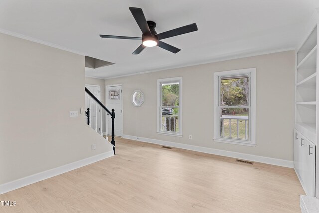 unfurnished living room featuring ornamental molding, stairway, light wood finished floors, and ceiling fan