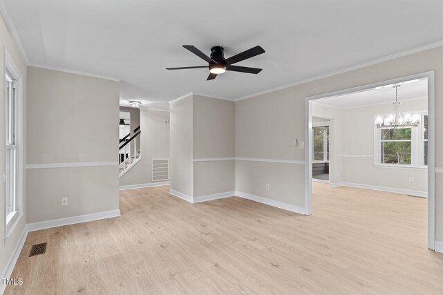 empty room featuring light wood-style flooring, ceiling fan with notable chandelier, stairs, and visible vents