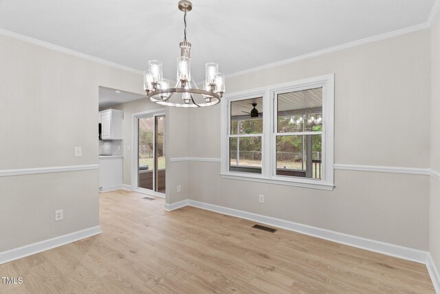 unfurnished dining area featuring a notable chandelier, crown molding, light wood finished floors, baseboards, and visible vents