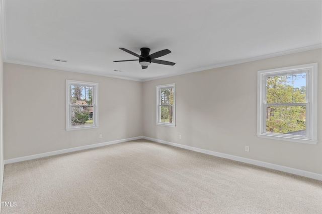 empty room featuring baseboards, ornamental molding, visible vents, and light carpet
