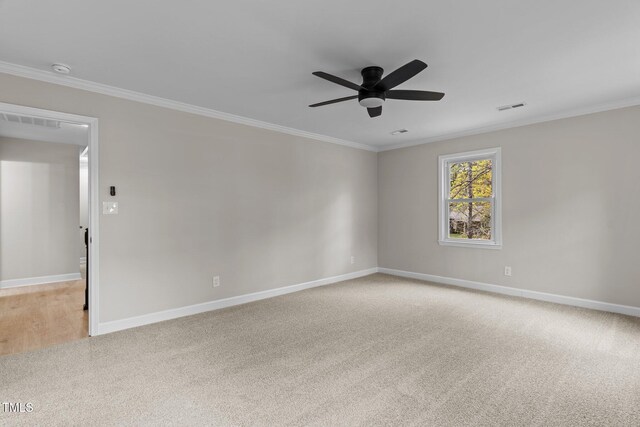 empty room with ornamental molding, a ceiling fan, light carpet, and visible vents