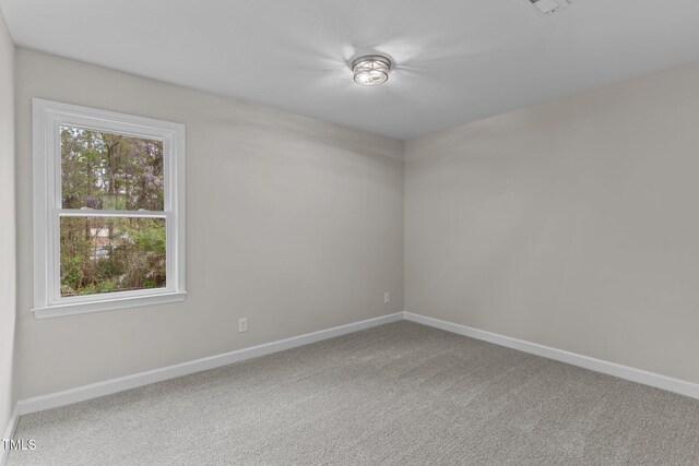 carpeted empty room with baseboards