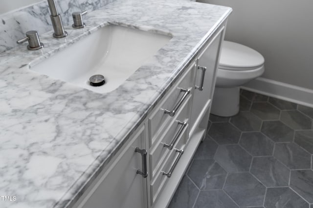 bathroom featuring baseboards, toilet, tile patterned flooring, and vanity