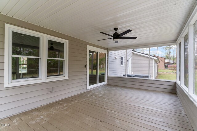 unfurnished sunroom featuring a ceiling fan