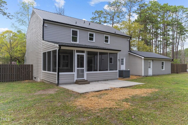 rear view of house with a patio area, central air condition unit, fence, a sunroom, and a yard