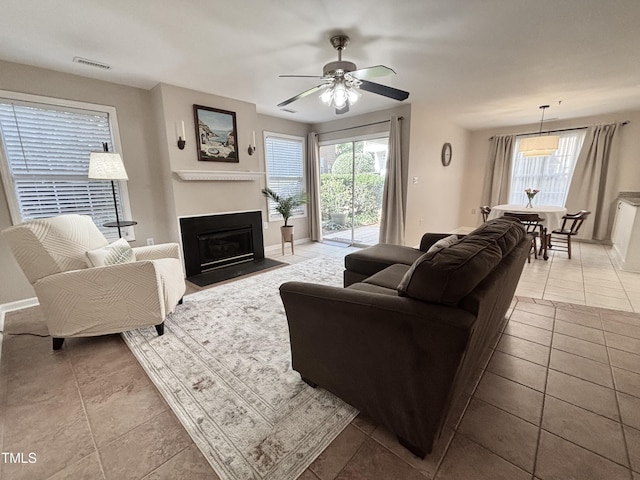 1613 Bulon Dr, Cary, NC 27518 - living room with healthy amount of natural light, a ceiling fan, a fireplace with flush hearth, and baseboards