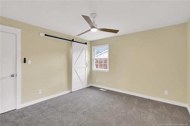 1772 Inverness Dr, Fayetteville, NC 28304 - unfurnished bedroom with a barn door, baseboards, a ceiling fan, and dark carpet