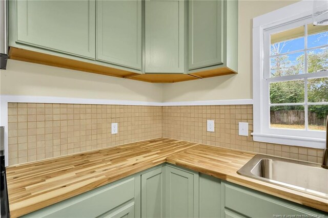 1772 Inverness Dr, Fayetteville, NC 28304 - kitchen with a sink, wood counters, green cabinets, and decorative backsplash