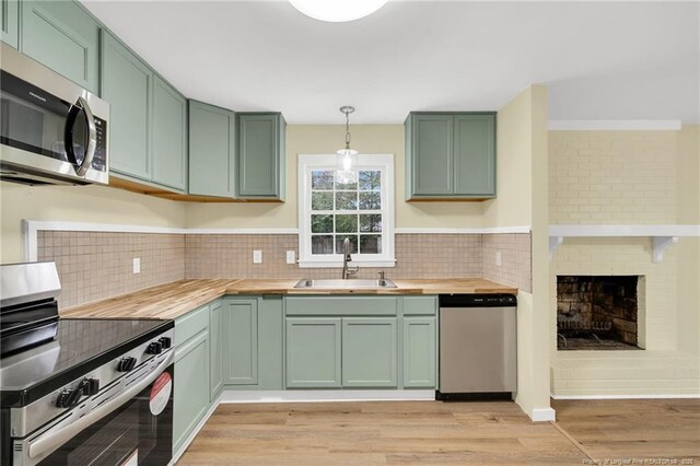 1772 Inverness Dr, Fayetteville, NC 28304 - kitchen featuring green cabinetry, butcher block countertops, stainless steel appliances, and a sink