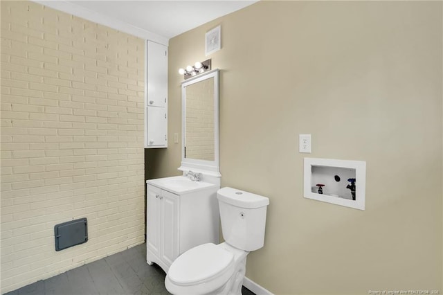 1772 Inverness Dr, Fayetteville, NC 28304 - bathroom featuring visible vents, brick wall, toilet, and vanity