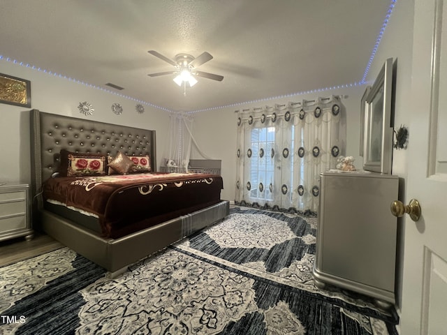 bedroom featuring visible vents, ceiling fan, and wood finished floors