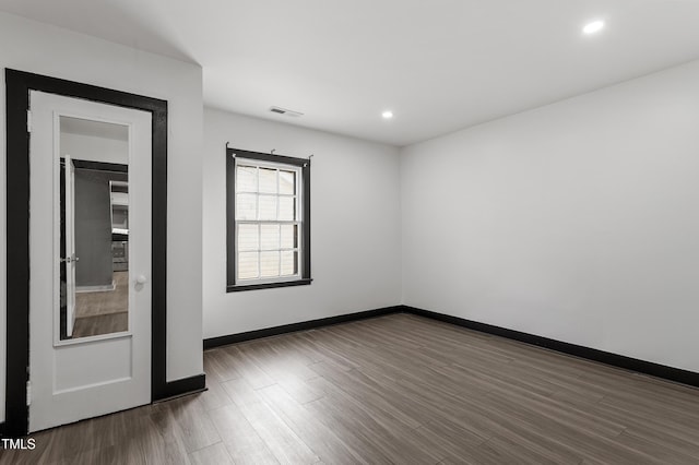 empty room with baseboards, visible vents, wood finished floors, and recessed lighting